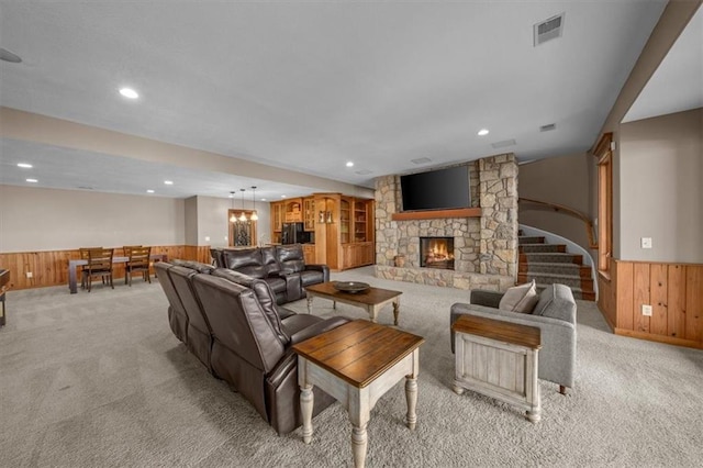 living area featuring visible vents, wainscoting, light colored carpet, and wood walls