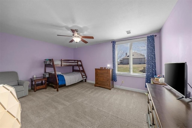 bedroom featuring visible vents, baseboards, light colored carpet, and a ceiling fan