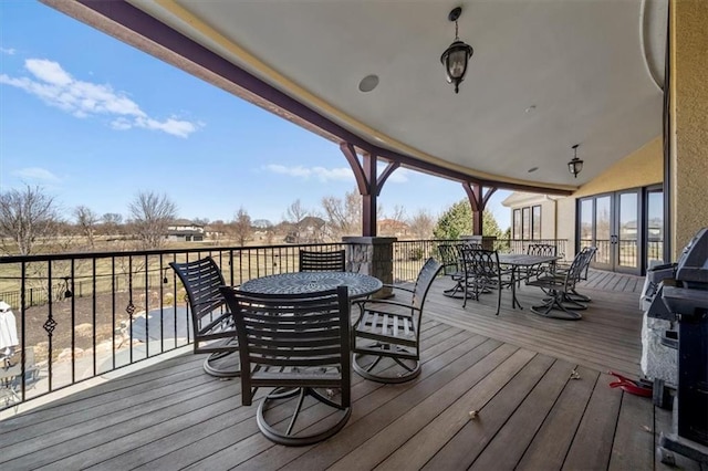 deck with outdoor dining area and grilling area