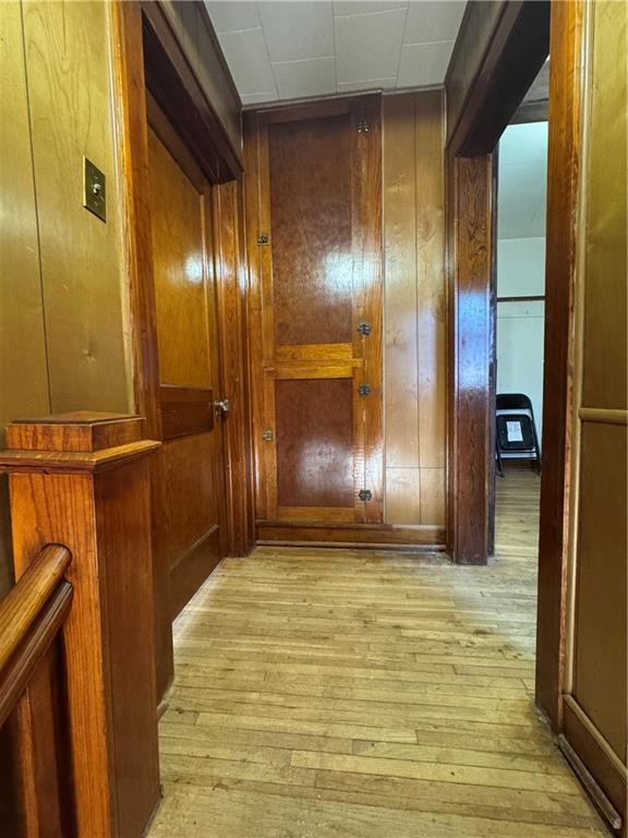 hall featuring wooden walls and light wood-type flooring