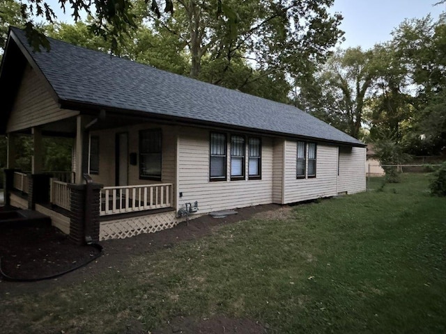 view of side of property with a porch and a lawn