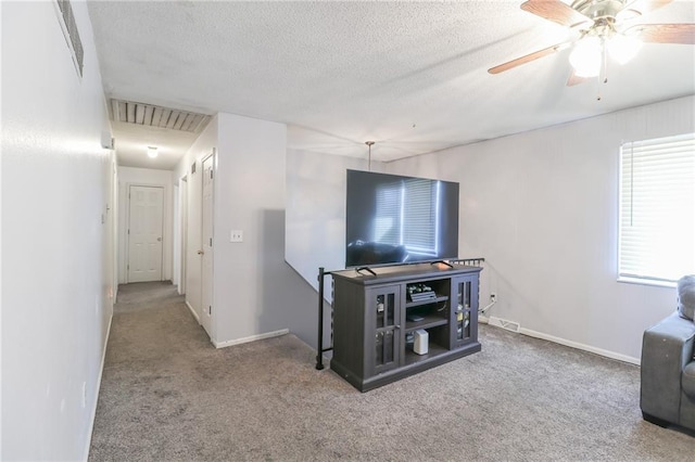 carpeted living room featuring ceiling fan and a textured ceiling