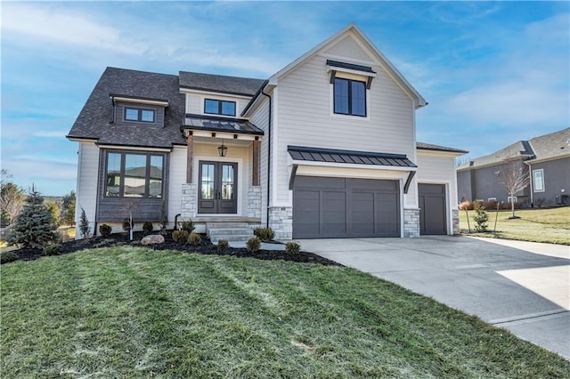 modern farmhouse featuring a front yard, french doors, driveway, and a standing seam roof