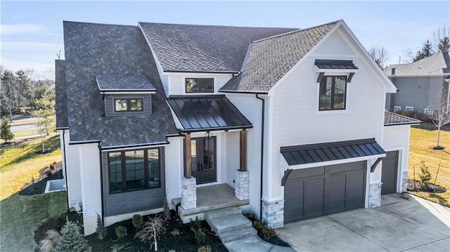 view of front of home with a garage, concrete driveway, metal roof, roof with shingles, and a standing seam roof