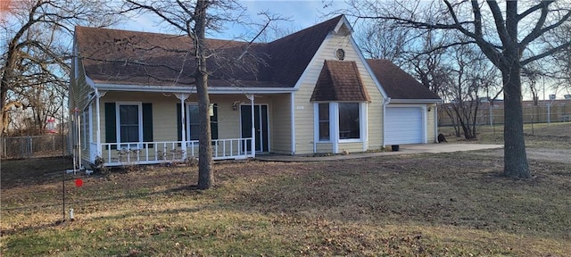 cape cod-style house with a garage, a front yard, and covered porch