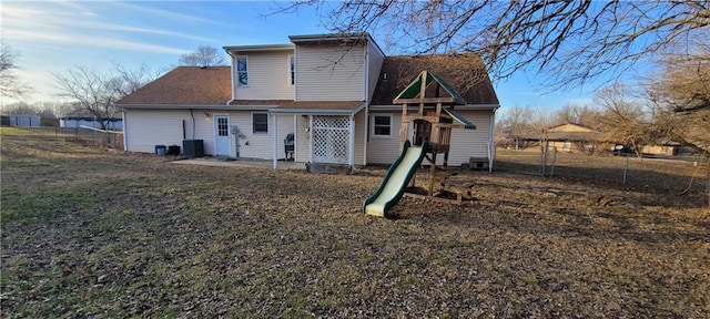 back of property featuring central AC, a playground, and a patio area