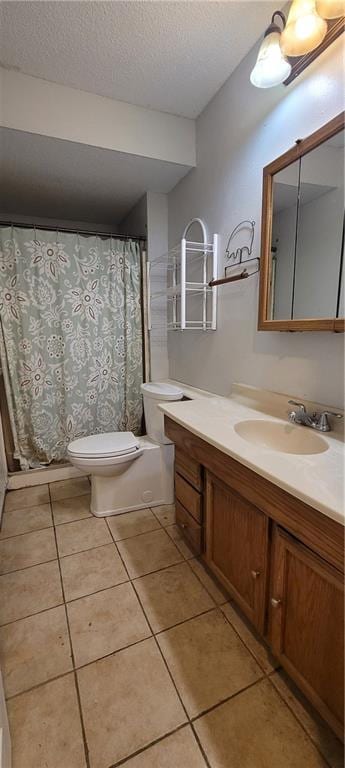 bathroom featuring vanity, toilet, tile patterned flooring, and a textured ceiling