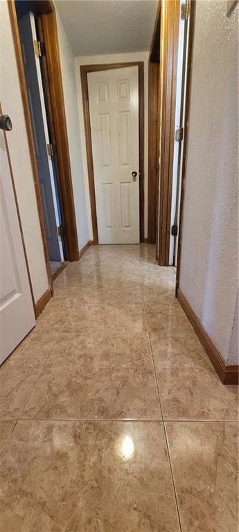 hall featuring a textured ceiling