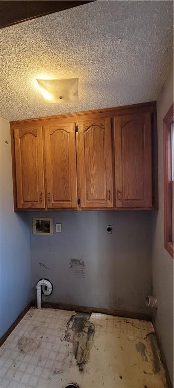 laundry area featuring cabinets, hookup for a washing machine, and a textured ceiling