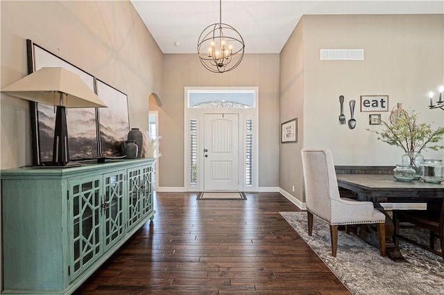 foyer with dark wood-style floors, baseboards, visible vents, and a chandelier