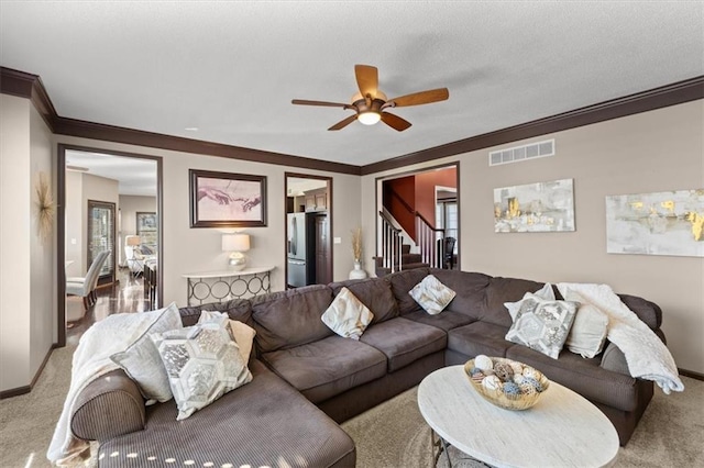 carpeted living area with ornamental molding, stairway, visible vents, and baseboards