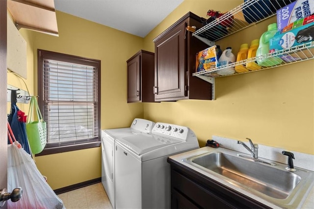 laundry area featuring cabinet space, baseboards, washer and dryer, and a sink