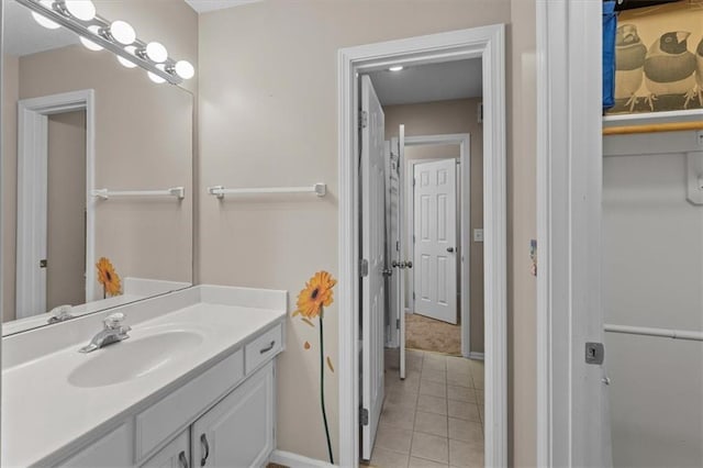 bathroom with vanity, baseboards, and tile patterned floors