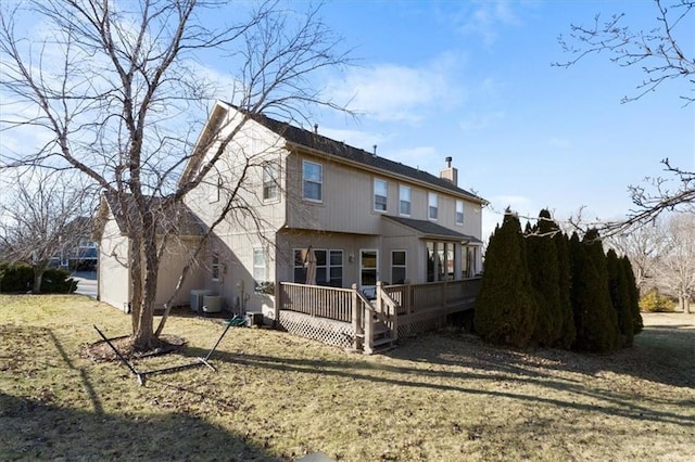 back of house featuring a chimney, central AC, and a wooden deck