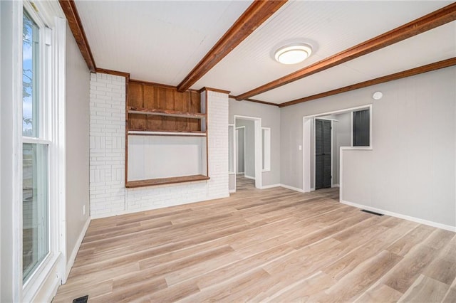 unfurnished living room featuring beam ceiling and light hardwood / wood-style floors