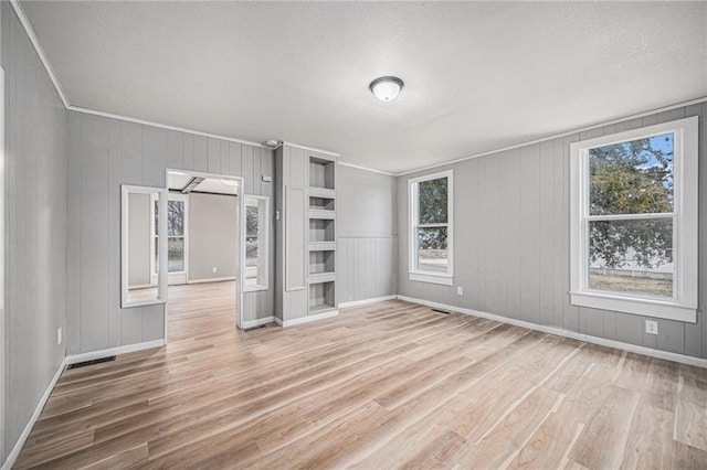 unfurnished room with light hardwood / wood-style floors and a textured ceiling