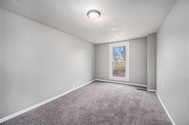 spare room featuring a textured ceiling and carpet