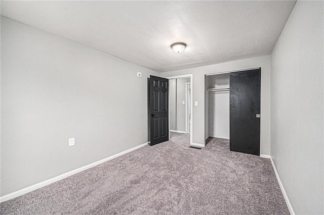 unfurnished bedroom with carpet flooring and a closet