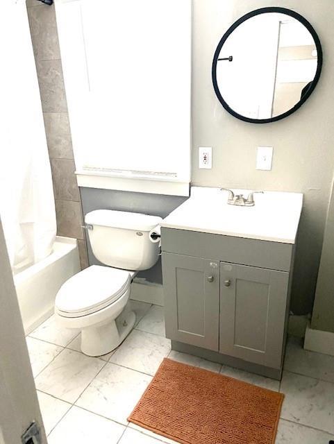 full bathroom featuring shower / tub combo with curtain, vanity, and toilet