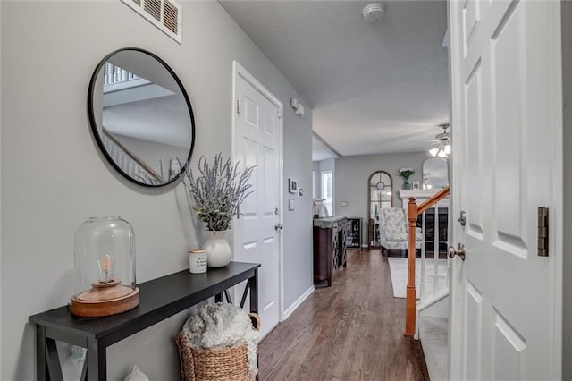 interior space with visible vents, ceiling fan, wood finished floors, baseboards, and stairs