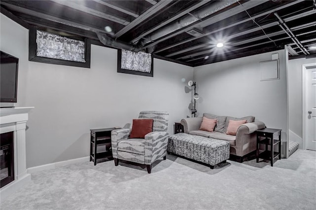 living room featuring baseboards, a glass covered fireplace, and light colored carpet