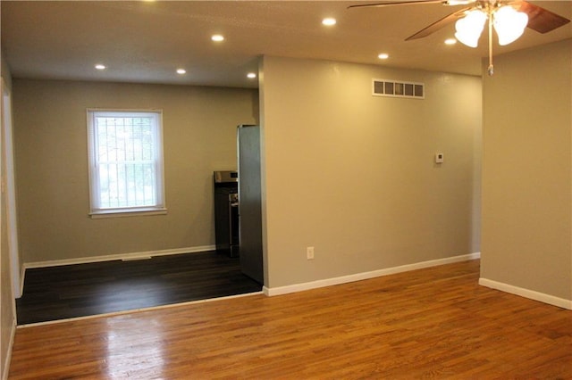 empty room with dark hardwood / wood-style floors and ceiling fan