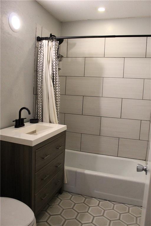 full bathroom featuring vanity, shower / bathtub combination with curtain, tile patterned floors, and toilet