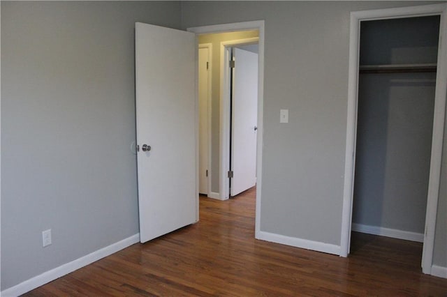 unfurnished bedroom featuring dark hardwood / wood-style flooring and a closet