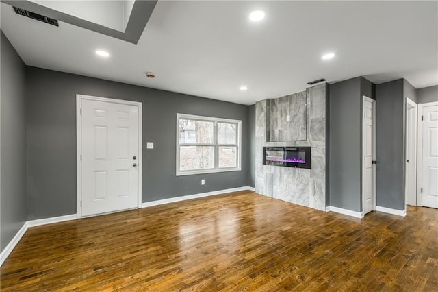 unfurnished living room with a large fireplace and hardwood / wood-style floors