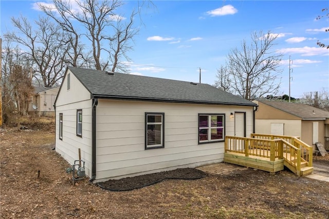 rear view of property featuring a wooden deck