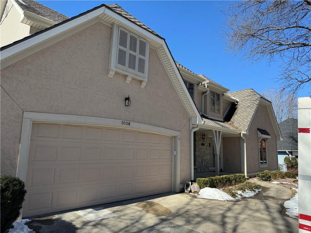 view of front of home with a garage, driveway, and stucco siding