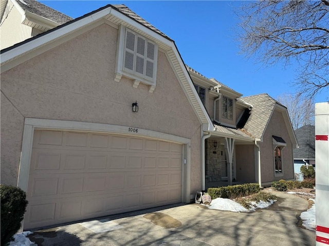 view of front of home with a garage, driveway, and stucco siding