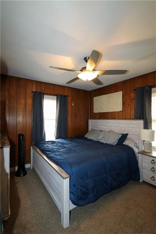 bedroom featuring ceiling fan, carpet, and wooden walls