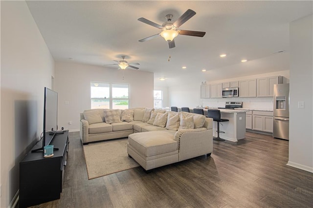 living room featuring dark wood-type flooring and ceiling fan