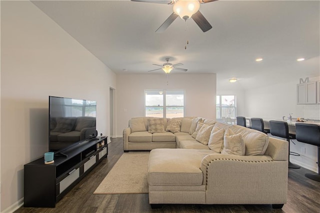 living room featuring ceiling fan and dark hardwood / wood-style floors