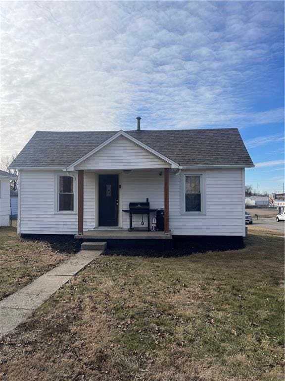 view of front of home with a porch and a front lawn