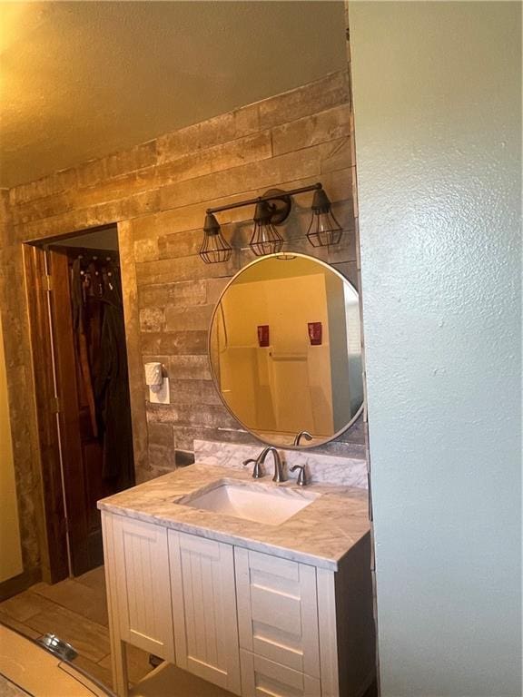 bathroom with vanity and wooden walls