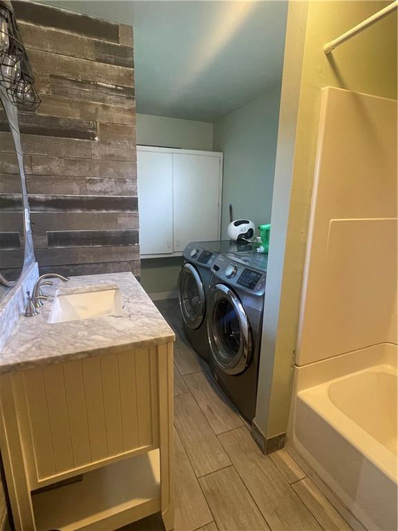 clothes washing area featuring sink and washer and dryer