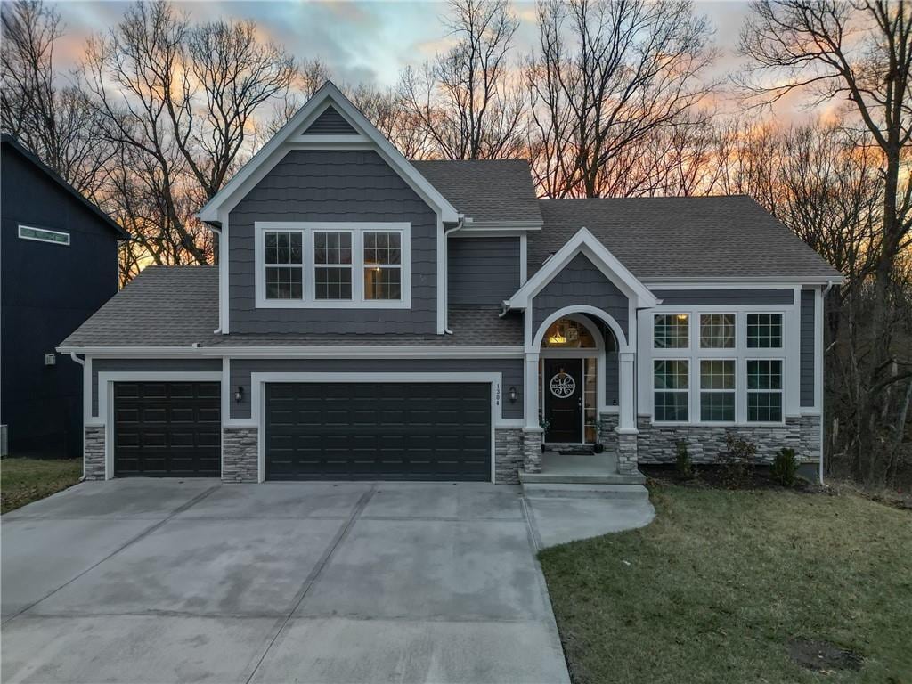 craftsman inspired home with a garage and a yard