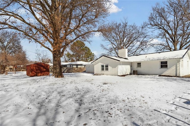 view of snow covered back of property