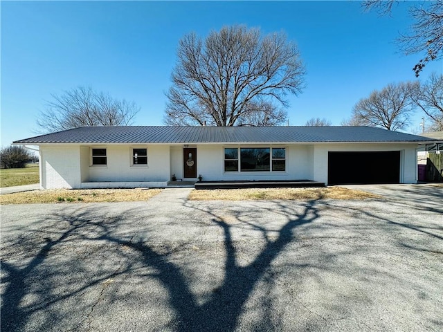 305 N Free King Hwy, Pittsburg, KS 66762 - ranch-style house featuring metal roof, a garage, stucco siding, and asphalt driveway