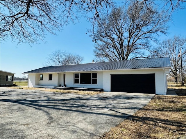 305 N Free King Hwy, Pittsburg, KS 66762 - view of front of home featuring asphalt driveway, metal roof, an attached garage, and stucco siding