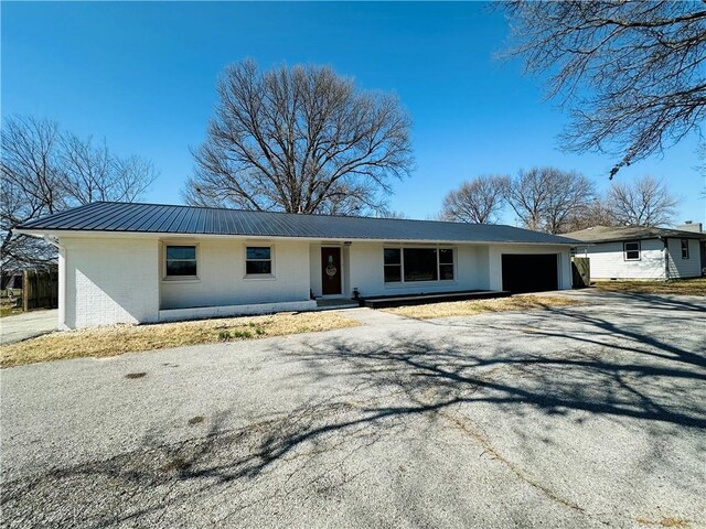 305 N Free King Hwy, Pittsburg, KS 66762 - ranch-style house featuring an attached garage, metal roof, driveway, and brick siding