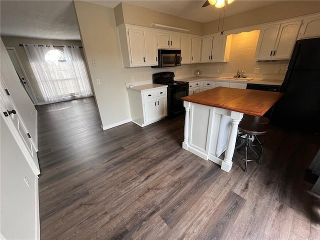 kitchen with a kitchen breakfast bar, white cabinets, dark hardwood / wood-style flooring, and black appliances