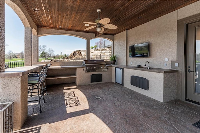 view of patio / terrace featuring a sink, an outdoor kitchen, outdoor wet bar, and grilling area