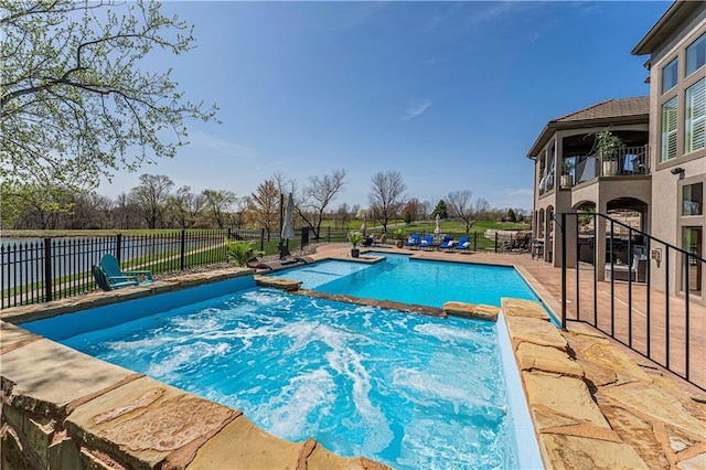 view of pool with fence, a patio area, and a pool with connected hot tub
