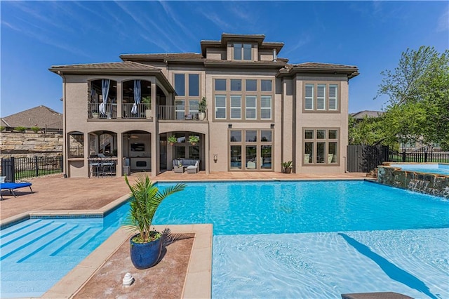 view of swimming pool with fence, a pool with connected hot tub, and a patio area