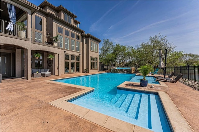 view of swimming pool featuring a patio, fence, an outdoor hangout area, and a pool with connected hot tub