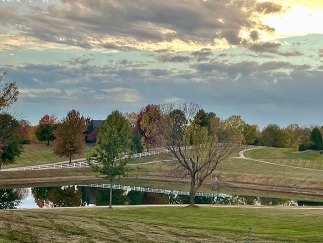 view of property's community featuring a lawn and a water view
