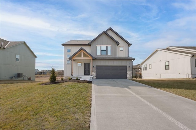 view of front of property with board and batten siding, a front yard, concrete driveway, and an attached garage